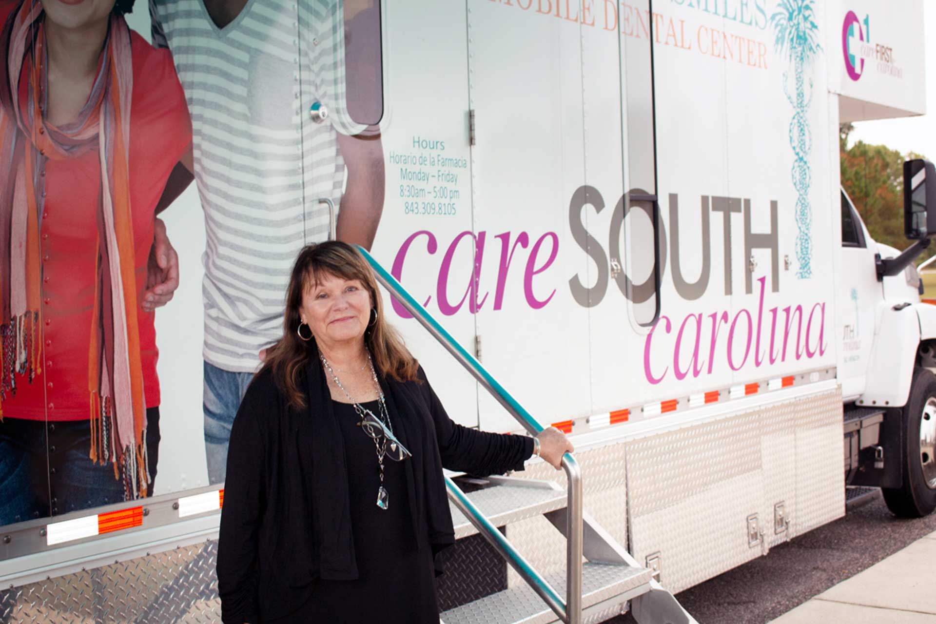 CareSouth Van out in the community and woman standing in front of van